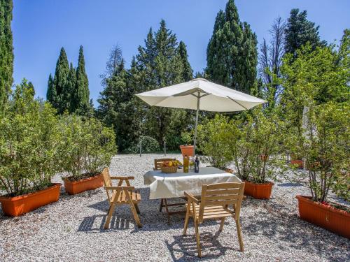 einen Tisch und Stühle mit Sonnenschirm in einem Garten in der Unterkunft Holiday Home Castiglioni-1 by Interhome in Castiglione