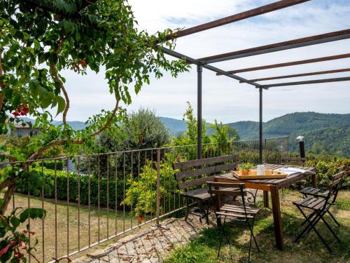 un patio con mesa, sillas y una valla en Apartment Giallo by Interhome, en Cortemilia