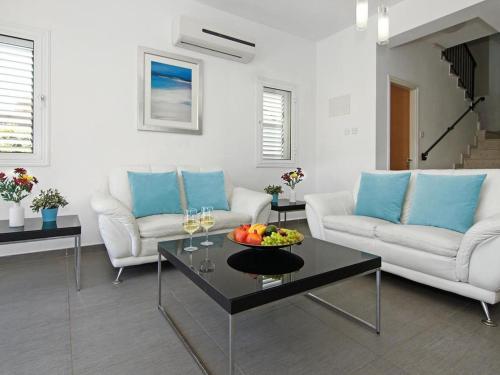 a living room with two couches and a table with fruit on it at Villa palm by Interhome in Protaras