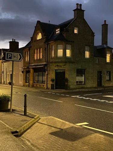 a building on a street with a one way sign at Frasers Apartment in Golspie