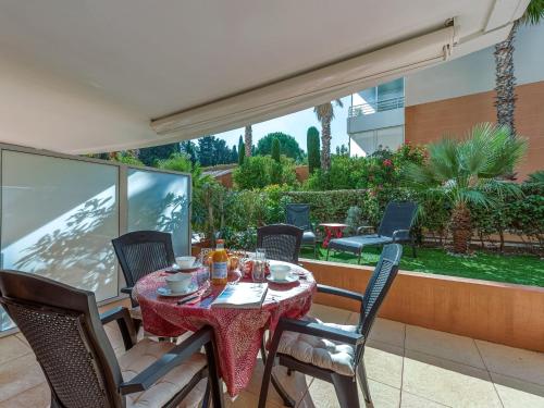 a table and chairs on a patio with a view at Apartment Le Domaine de la Baie-3 by Interhome in Cavalaire-sur-Mer