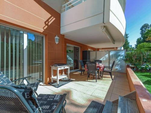 un patio avec des chaises et une table sur un balcon dans l'établissement Apartment Le Domaine de la Baie-3 by Interhome, à Cavalaire-sur-Mer