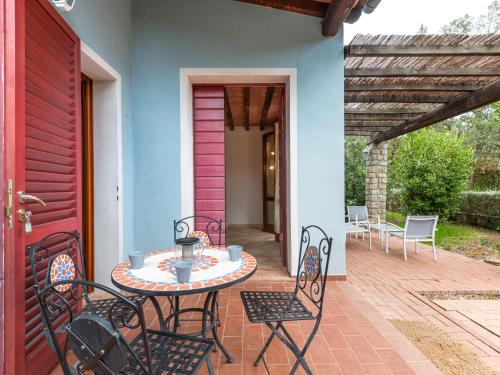 リオ・マリーナにあるHoliday Home Villaggio Mezzo Ortano-1 by Interhomeの赤いドア、パティオ(テーブル、椅子付)