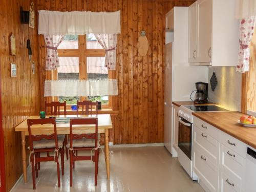 eine Küche mit einem Tisch und Stühlen sowie einem Fenster in der Unterkunft Holiday Home Elvehuset - FJS075 by Interhome in Holsen