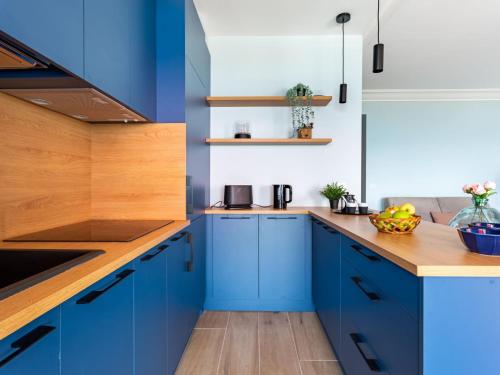 une cuisine avec des armoires bleues et des comptoirs en bois dans l'établissement Apartment de la mer by Interhome, à Villeneuve-Loubet