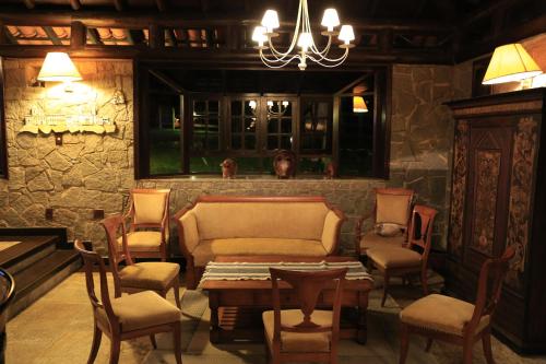a living room with a couch and a table and chairs at Auberge Suisse Pousada in Nova Friburgo
