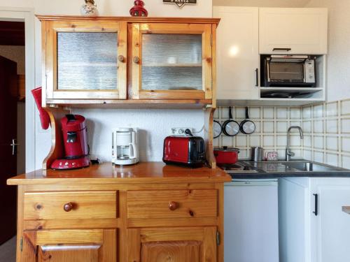 une cuisine avec un appareil rouge sur un comptoir en bois dans l'établissement Studio Ariane-5 by Interhome, au Corbier