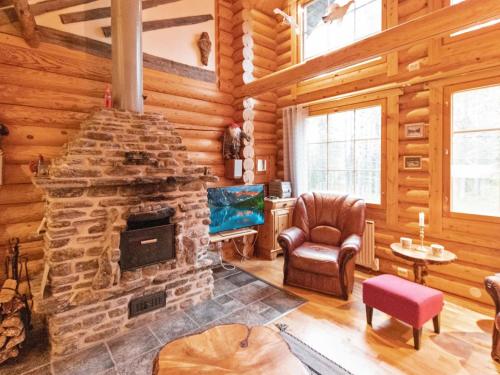a living room with a stone fireplace in a log cabin at Holiday Home Tievanlaita 10 by Interhome in Äkäslompolo