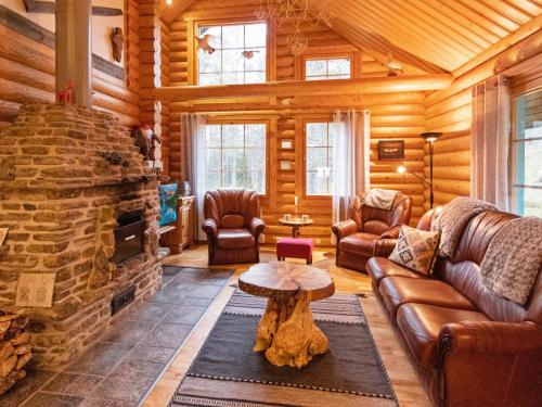 Cabaña de madera con sala de estar con chimenea de piedra. en Holiday Home Tievanlaita 10 by Interhome en Äkäslompolo