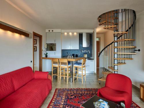 ein Wohnzimmer mit einem roten Sofa und einer Küche in der Unterkunft Apartment Isabella by Interhome in Consiglio di Rumo