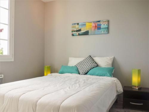 a bedroom with a large white bed with green pillows at Apartment Amigorena-1 by Interhome in Bidart