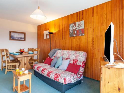 ein Wohnzimmer mit Sofa und Tisch in der Unterkunft Apartment L'Edioule by Interhome in La Toussuire