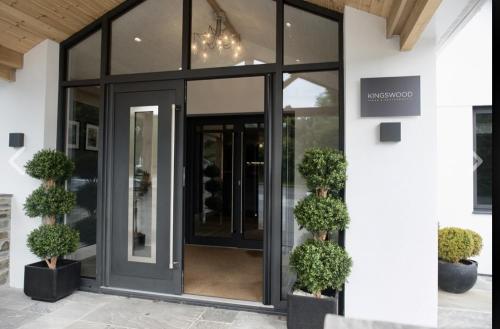 a glass entrance to a building with potted plants at The Kingswood in St Austell