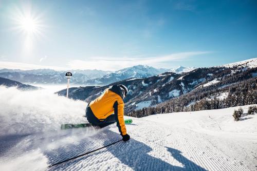 a person is skiing down a snow covered slope at Spa Chalet by we rent in Zell am See