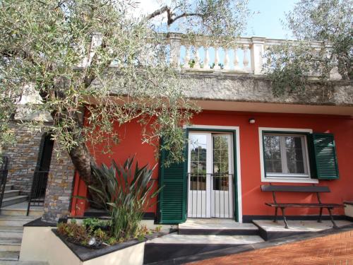 uma casa vermelha com persianas verdes e uma árvore em Apartment Il Risveglio by Interhome em Gorleri