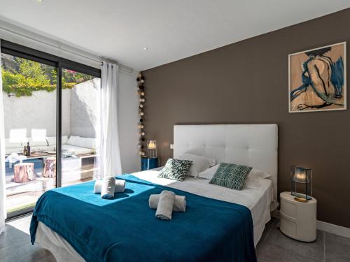 a bedroom with a large bed with a blue blanket at Holiday Home St Cyprien Plage by Interhome in San Ciprianu