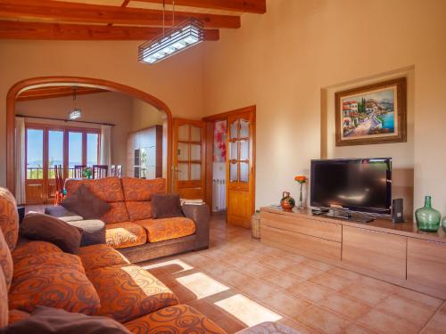 uma sala de estar com um sofá e uma televisão de ecrã plano em Villa Sa Tanca by Interhome em Portol