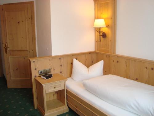 a bedroom with two beds and a table with a lamp at Gasthof & Hotel Jägerwirt in Aufhofen