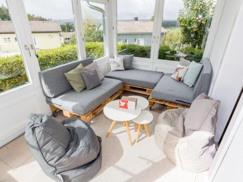a screened in porch with two couches and a table and chairs at Holiday Home Nest by Interhome in Dittishausen