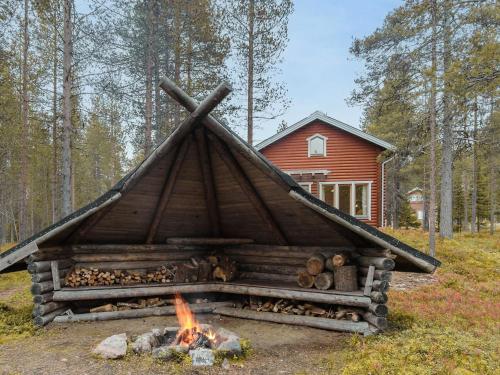 a log cabin with a fire in front of it at Holiday Home Kevätruska b by Interhome in Sirkka