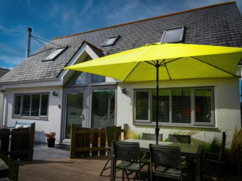 クロイドにあるHoliday Home Beach House by Interhomeの家の前のテーブルの上の黄色い傘