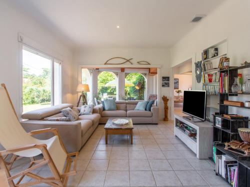 un salon avec un canapé et une télévision dans l'établissement Holiday Home Ile de France by Interhome, à Labenne