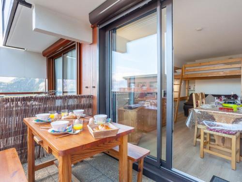 una sala da pranzo con un tavolo con del cibo sopra di Apartment Pegase Phenix-70 by Interhome a Le Corbier