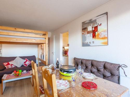 a living room with a table and a couch at Apartment Pegase Phenix-70 by Interhome in Le Corbier