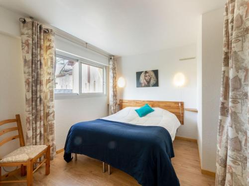 ein Schlafzimmer mit einem Bett, einem Stuhl und einem Fenster in der Unterkunft Apartment le Grand Foc-1 by Interhome in Capbreton