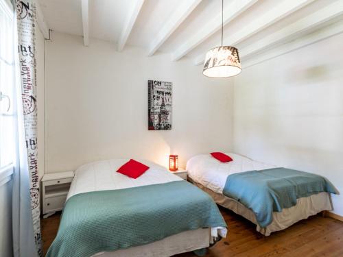 two beds in a room with white walls at Holiday Home Pyrénées by Interhome in Capbreton