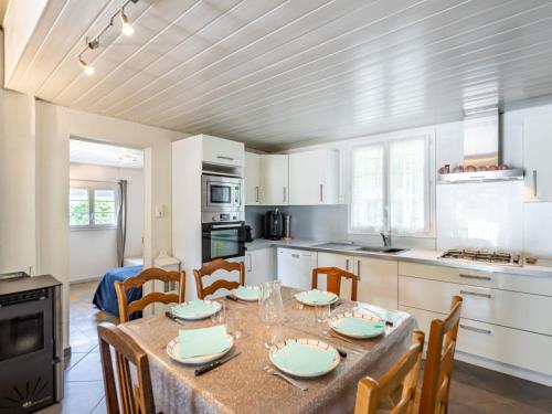 a kitchen with a table and chairs and a kitchen with white cabinets at Holiday Home Pyrénées by Interhome in Capbreton