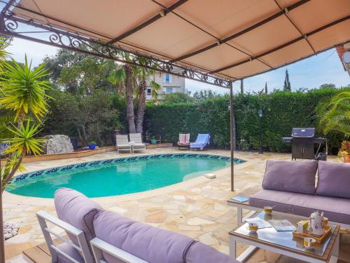 - une piscine avec un canapé violet et un parasol dans l'établissement Villa Villa Les Galandos by Interhome, à Saint-Aygulf