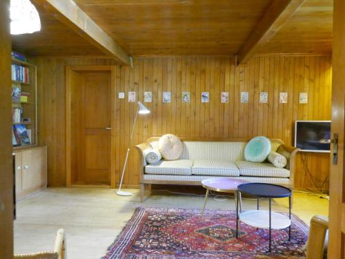 a living room with a couch and a tv at Chalet Chalet Wychel 8B by Interhome in Innertkirchen