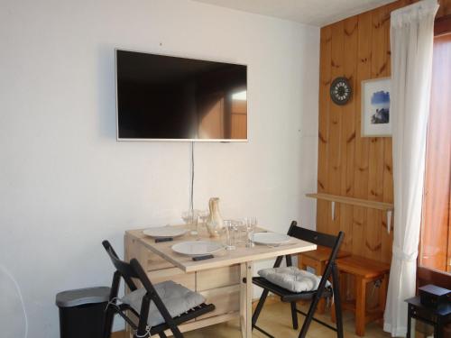 una sala da pranzo con tavolo, sedie e TV di Apartment Pointe des Aravis-5 by Interhome a Saint-Gervais-les-Bains