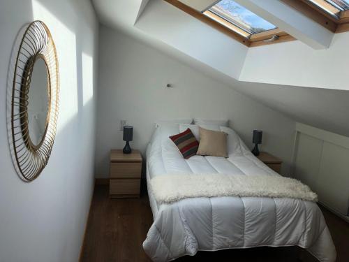 une chambre avec un lit avec un miroir et une fenêtre dans l'établissement MALIBAIX, à Aix-les-Bains