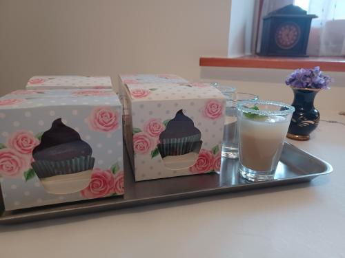 a gift box and a glass of drink on a tray at Tulipán Ház in Bodony