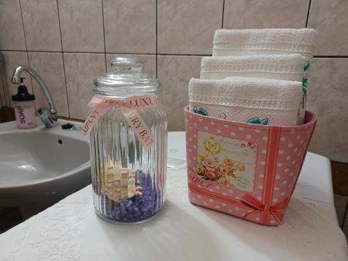 um balcão de casa de banho com uma garrafa de pasta de dentes e toalhas em Tulipán Ház em Bodony