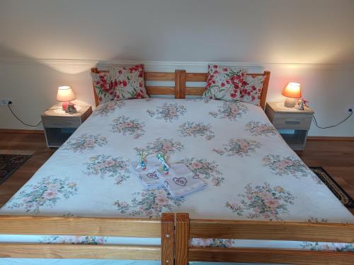 Un dormitorio con una cama con flores. en Tulipán Ház, en Bodony