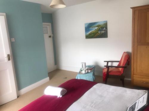 a bedroom with a bed and a chair at Butlers (St Ivers House) in Broadway