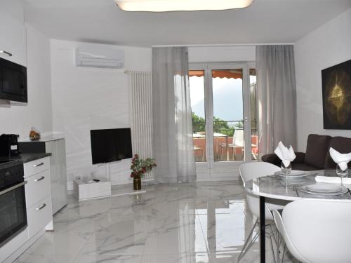 - un salon blanc avec une table et une télévision dans l'établissement Apartment Lago di Lugano-9 by Interhome, à Bissone
