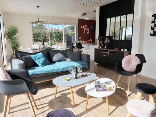 een woonkamer met een blauwe bank en stoelen bij Holiday Home Villa Ty Coz by Interhome in Cléder