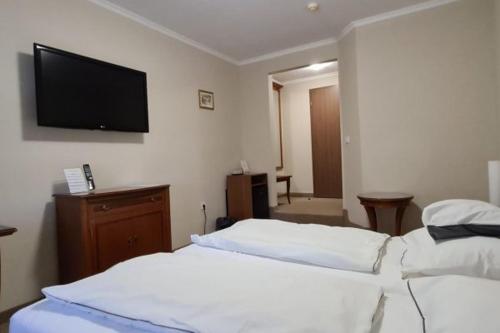 Habitación de hotel con 2 camas y TV de pantalla plana. en Korona Panzió, en Hatvan