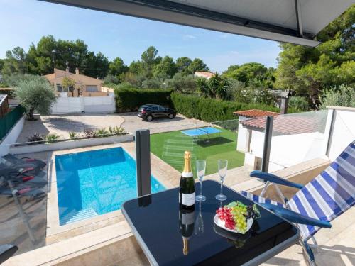uma villa com uma piscina e uma mesa com copos de vinho em Villa Isabel by Interhome em L'Ametlla de Mar