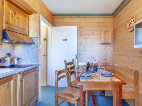 une cuisine avec une table en bois et une table et des chaises dans l'établissement Apartment Baikonour-7 by Interhome, au Corbier