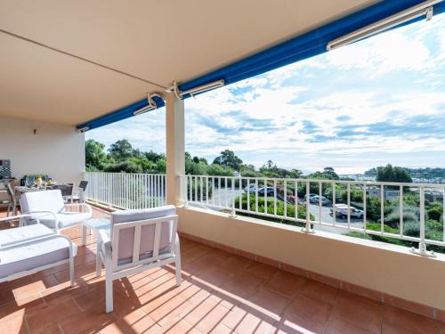 Elle comprend un balcon doté d'un mobilier blanc et offrant une vue sur l'eau. dans l'établissement Apartment Les Mimosas-6 by Interhome, à Cavalaire-sur-Mer