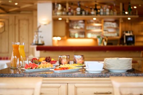 a buffet with plates of food on a counter at Hotel Bianca in Lech am Arlberg