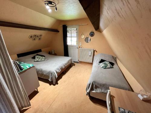 Cette petite chambre comprend deux lits et une table. dans l'établissement La Chaumière, à Saint-Martin-Saint-Firmin