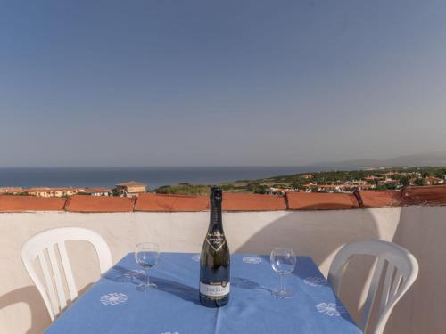 una botella de vino sentada en una mesa con dos copas en Holiday Home Valentina by Interhome, en Valledoria
