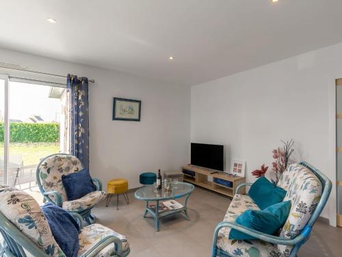- un salon avec des chaises, une table et une télévision dans l'établissement Holiday Home Villa Kerlina by Interhome, à Cléder