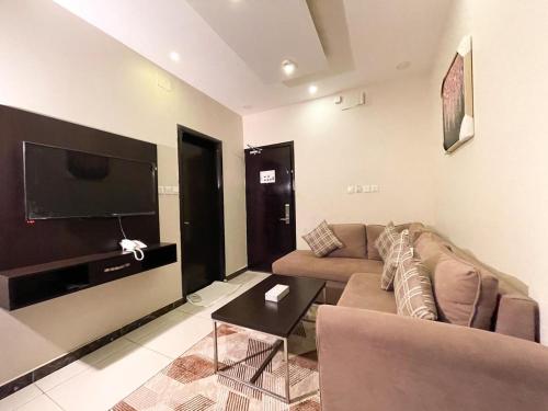 a living room with a couch and a flat screen tv at رفاف أبها للأجنحة الفندقية2 in Sirr Āl Ghalīz̧